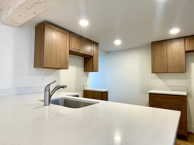 kitchen featuring a sink, brown cabinets, and recessed lighting