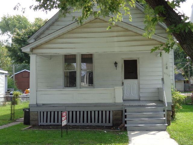 bungalow featuring a porch and fence