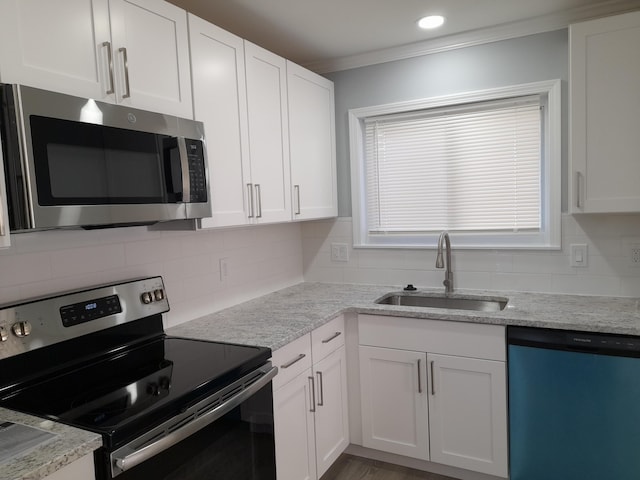 kitchen with a sink, white cabinets, backsplash, and stainless steel appliances