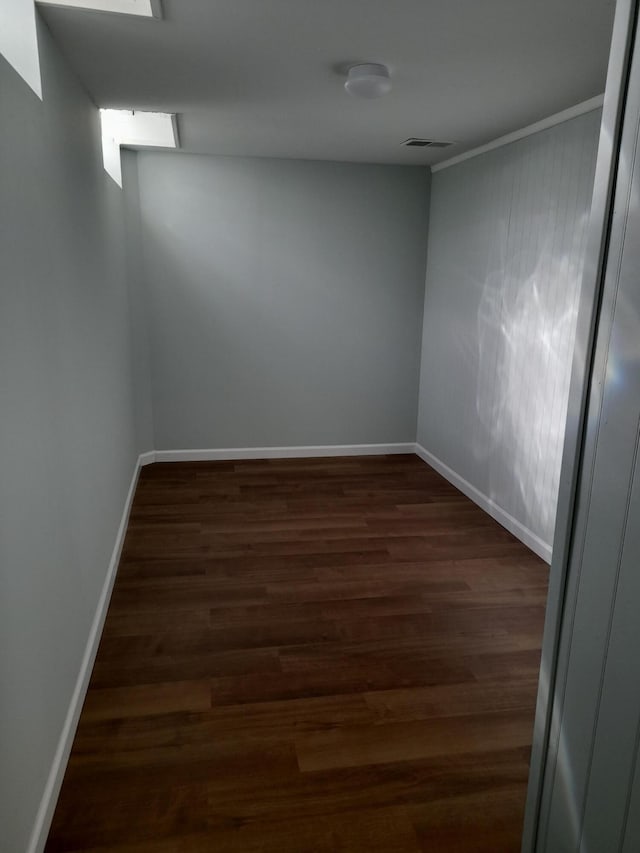 empty room with visible vents, baseboards, and wood finished floors