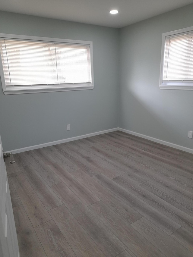 empty room featuring recessed lighting, baseboards, and wood finished floors