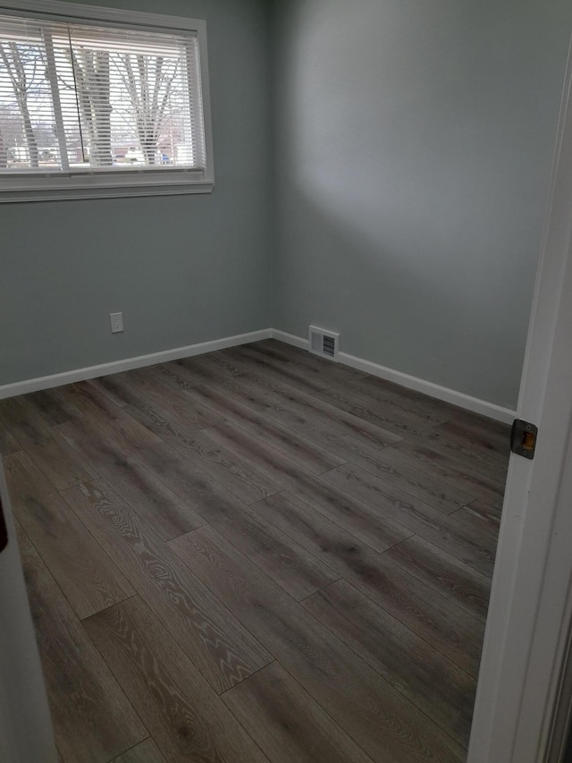 empty room with visible vents, baseboards, and wood finished floors