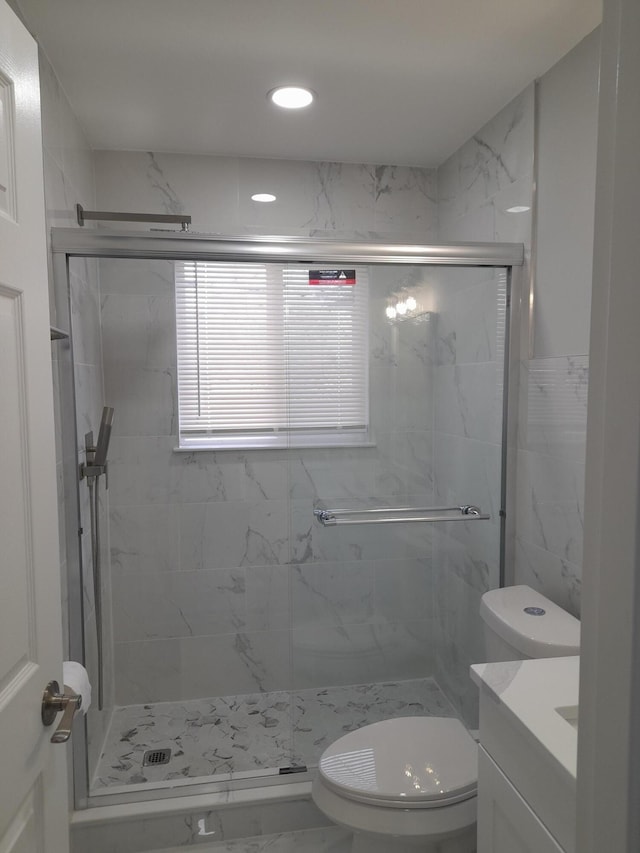 bathroom featuring a marble finish shower, toilet, and vanity