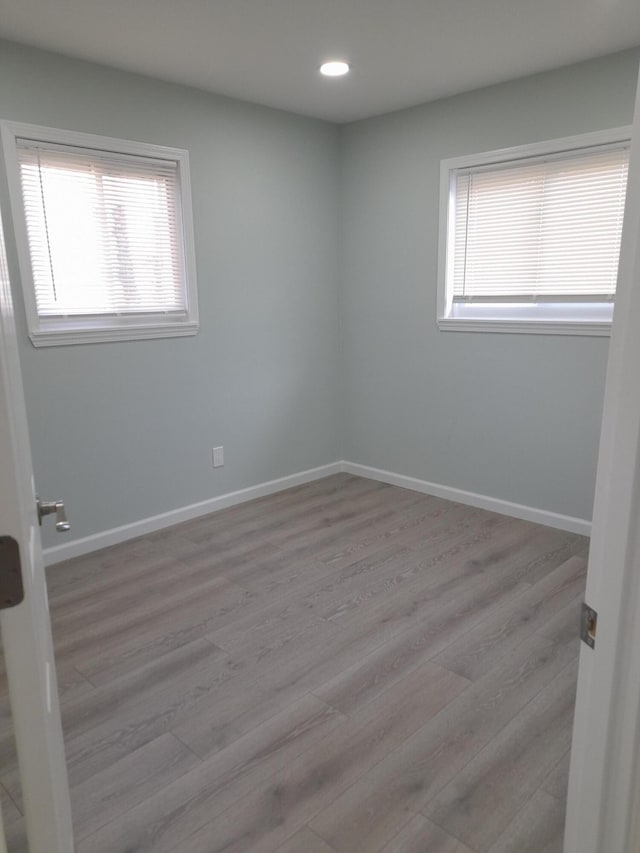 spare room featuring recessed lighting, baseboards, and light wood-style floors