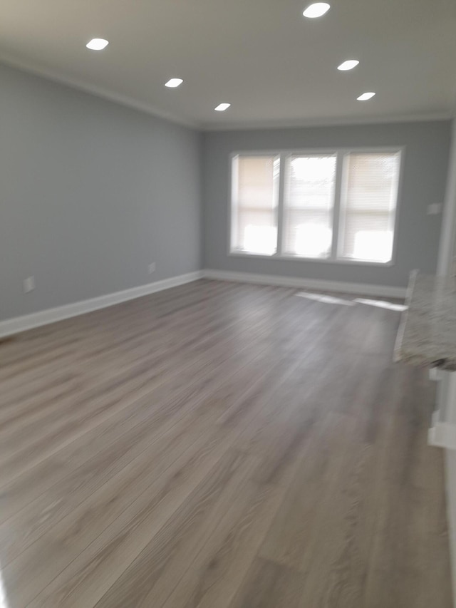 unfurnished room featuring recessed lighting, wood finished floors, and baseboards