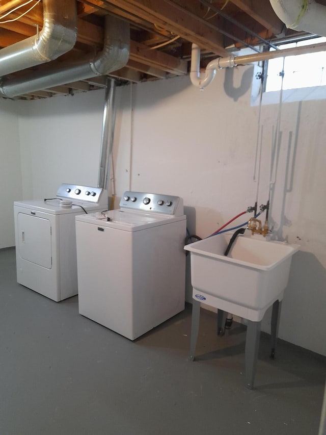 washroom featuring a sink, washing machine and dryer, and laundry area