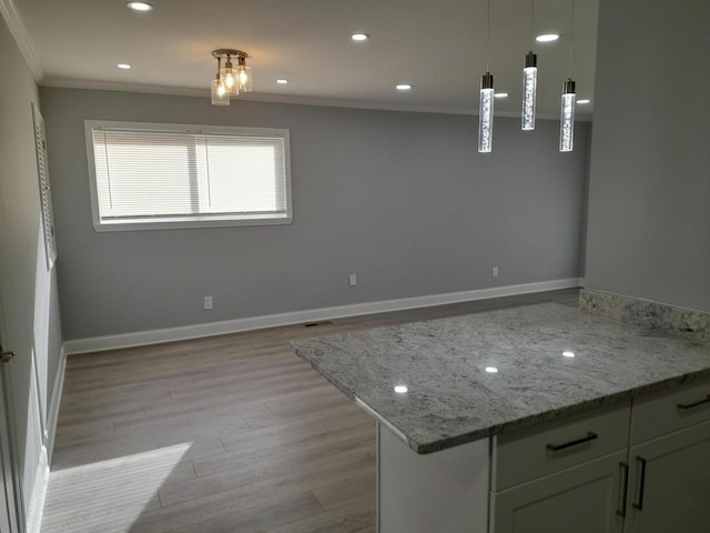 kitchen with baseboards, light wood finished floors, recessed lighting, crown molding, and decorative light fixtures