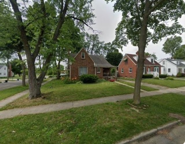 2126 Pierce St, Flint, MI 48503 - bungalow-style house with a residential view, brick siding, and a front yard