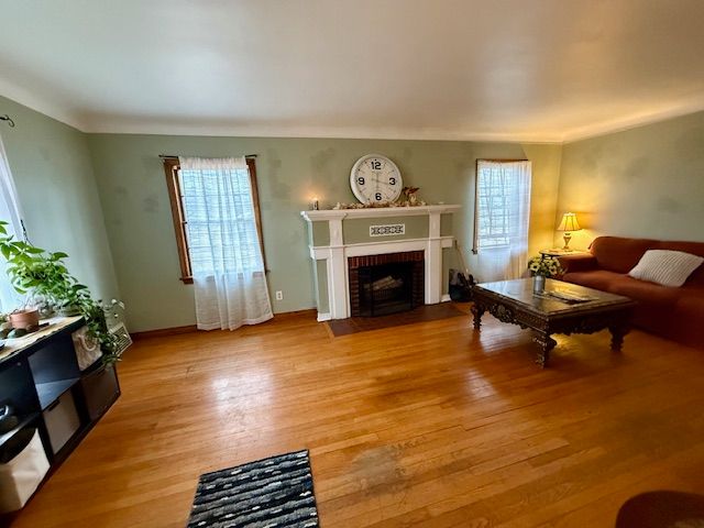 2126 Pierce St, Flint, MI 48503 - living area with baseboards, light wood-style flooring, and a brick fireplace