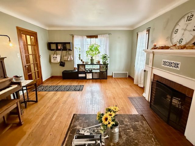 2126 Pierce St, Flint, MI 48503 - sitting room featuring crown molding, a fireplace, hardwood / wood-style floors, baseboards, and visible vents