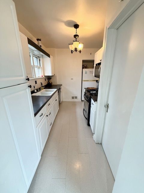 2126 Pierce St, Flint, MI 48503 - kitchen featuring white cabinets, dark countertops, a sink, visible vents, and black appliances