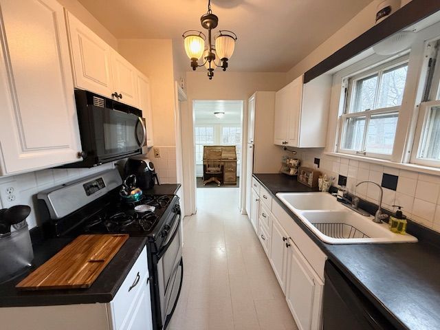 2126 Pierce St, Flint, MI 48503 - kitchen featuring a sink, white cabinetry, black appliances, and tasteful backsplash