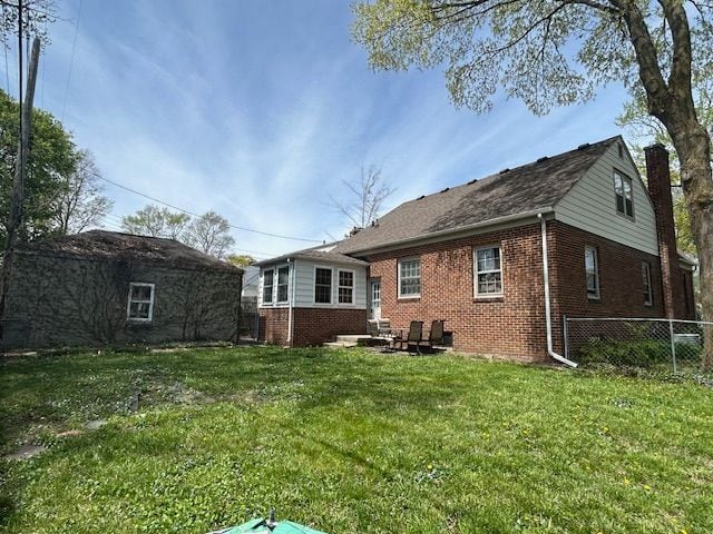 2126 Pierce St, Flint, MI 48503 - back of property with fence, a yard, and brick siding
