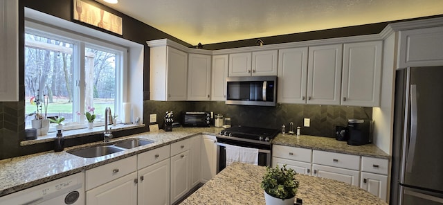 kitchen featuring white cabinets, appliances with stainless steel finishes, and a sink