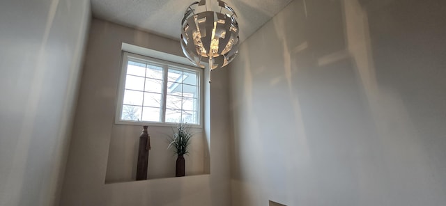 interior details with a textured ceiling and an inviting chandelier