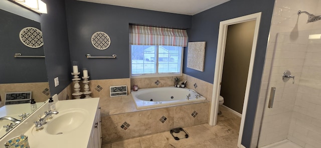 bathroom with a tub with jets, a shower stall, toilet, and vanity