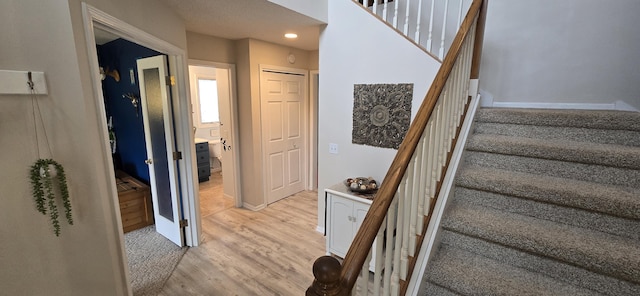 staircase featuring recessed lighting, baseboards, and wood finished floors