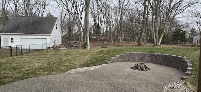 view of yard featuring a patio, fence, a garage, and an outdoor fire pit