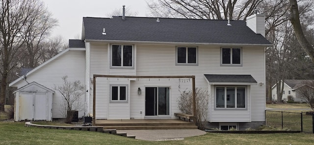 back of house featuring a lawn, a chimney, a deck, and fence