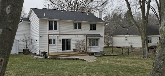 back of house with a deck, fence, a lawn, and a chimney