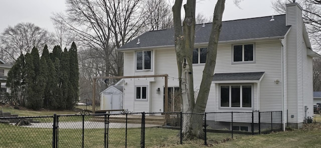 rear view of property with a shingled roof, a lawn, a chimney, and fence