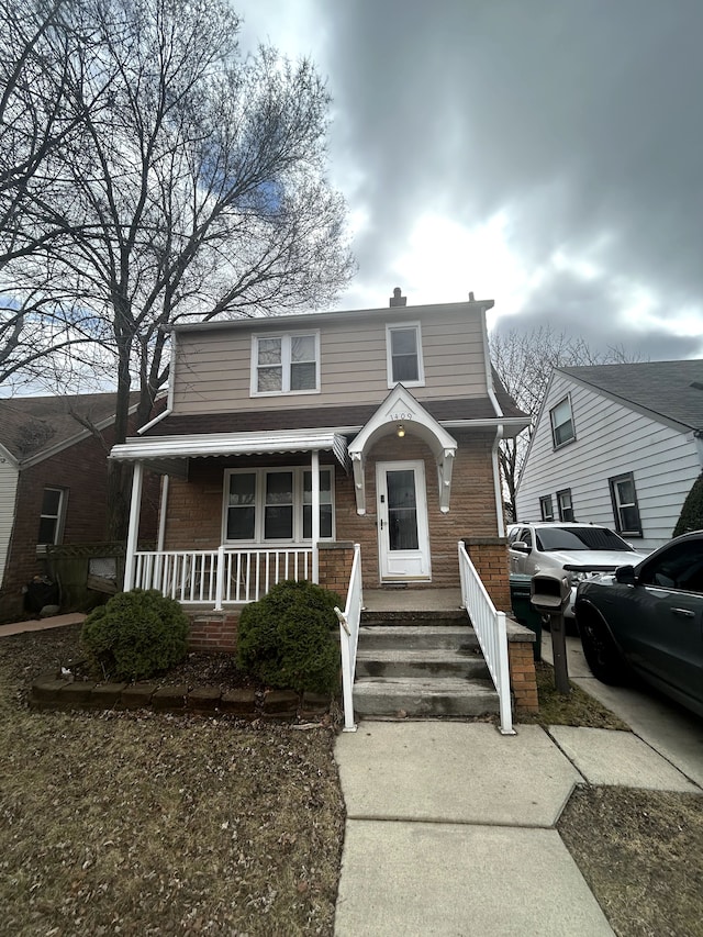 view of front of home featuring brick siding and a porch