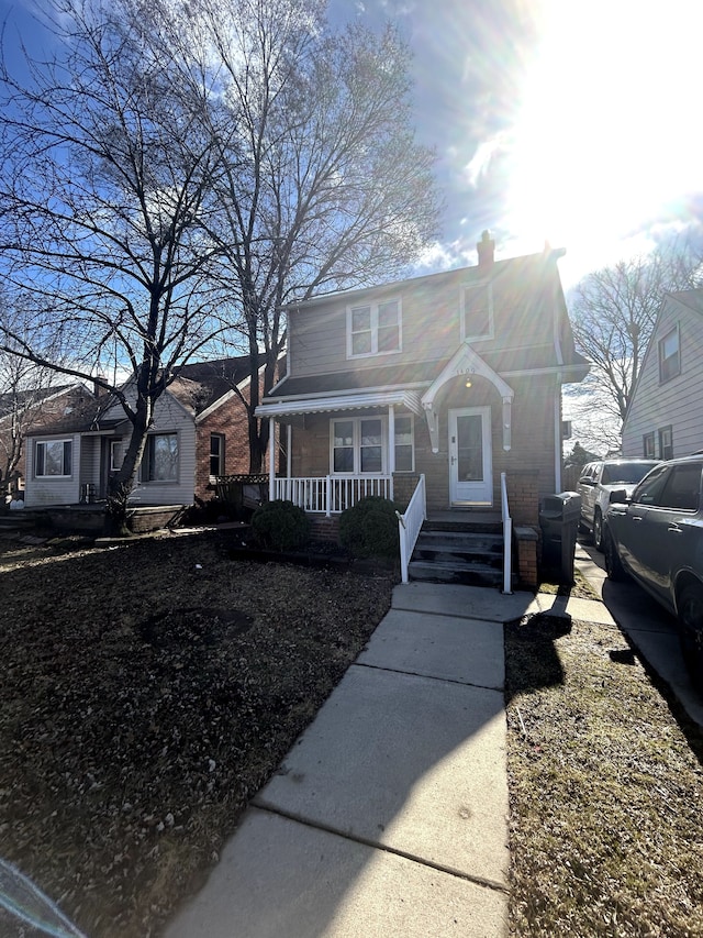 bungalow featuring a porch and a chimney