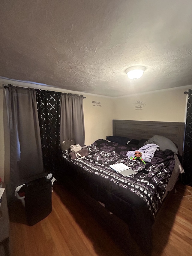 bedroom with wood finished floors and a textured ceiling