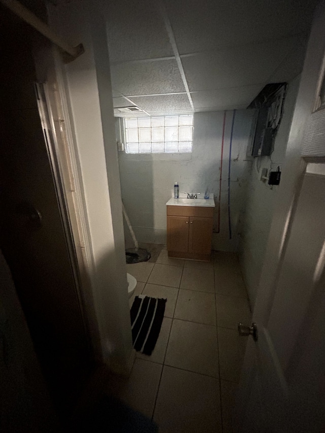 full bathroom with walk in shower, toilet, tile patterned floors, vanity, and a paneled ceiling