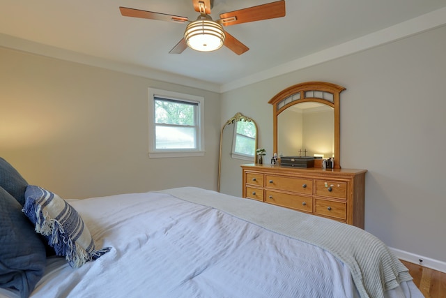 bedroom featuring wood finished floors, baseboards, and ceiling fan