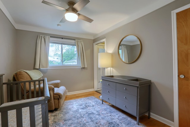 bedroom with light wood-type flooring, baseboards, and a ceiling fan