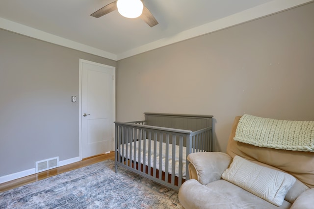 bedroom featuring wood finished floors, baseboards, and a ceiling fan