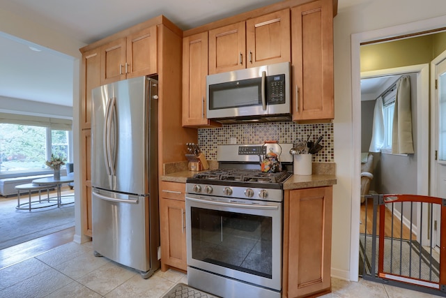 kitchen featuring appliances with stainless steel finishes, decorative backsplash, and light tile patterned flooring