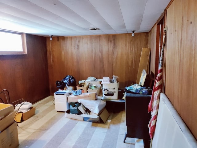 interior space with tile patterned floors, visible vents, and wooden walls