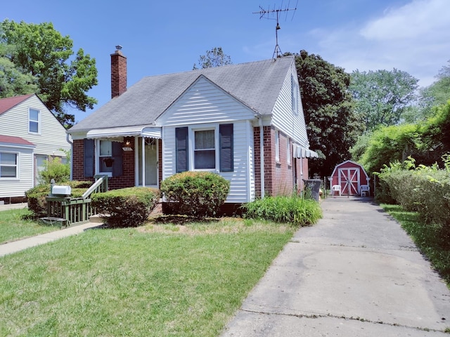 bungalow with an outbuilding, a front yard, a chimney, a storage unit, and brick siding