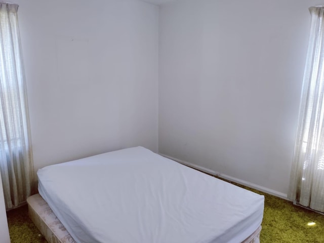 bedroom featuring baseboards and light colored carpet