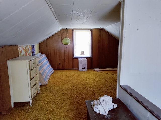 bonus room with lofted ceiling, wood walls, and light carpet