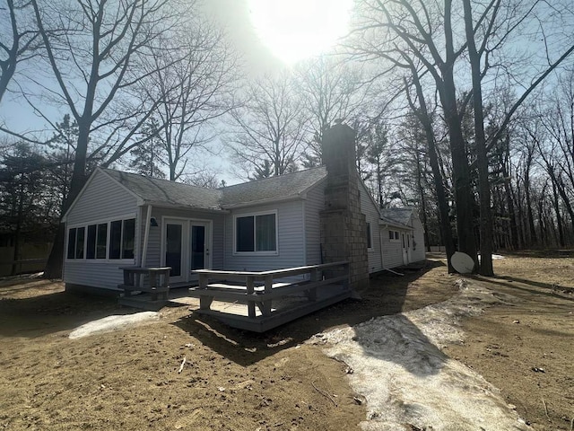 exterior space with french doors, a deck, and roof with shingles