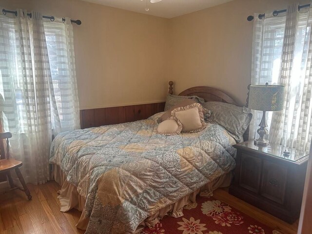 bedroom with multiple windows and wood finished floors