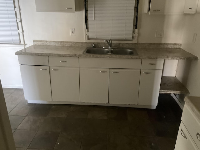 kitchen featuring white cabinetry and a sink