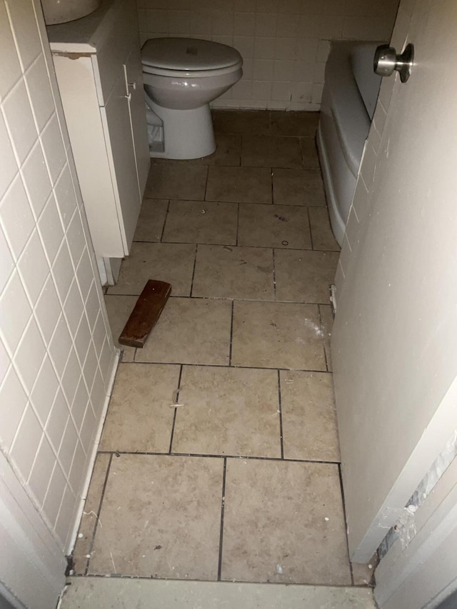 bathroom with tile patterned floors, toilet, and a bath