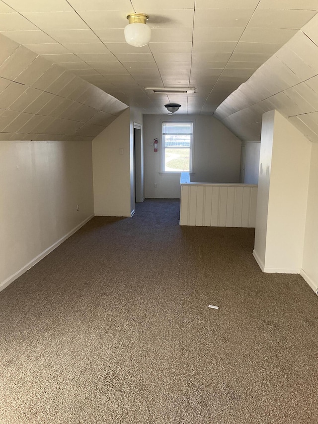 additional living space featuring baseboards, lofted ceiling, and carpet flooring