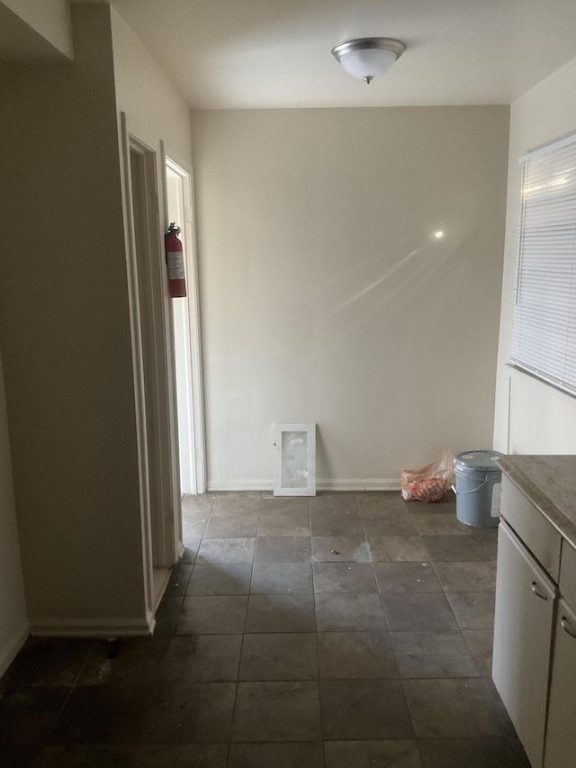 hallway with dark tile patterned floors