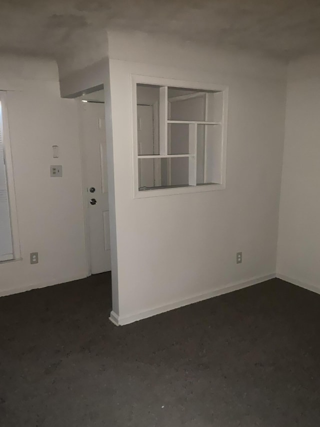 unfurnished room featuring unfinished concrete floors and baseboards