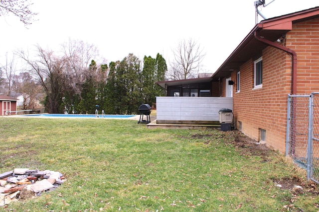 view of yard featuring an outdoor pool and a sunroom