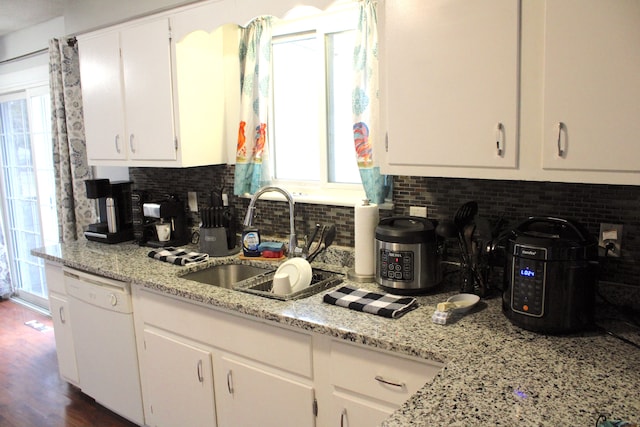 kitchen featuring a sink, backsplash, white dishwasher, white cabinetry, and dark wood-style flooring