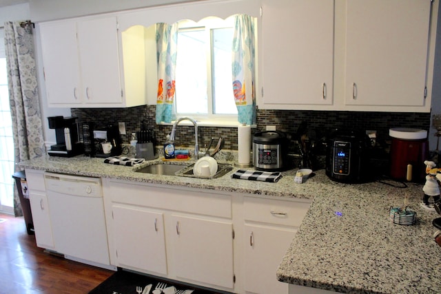 kitchen featuring dishwasher, white cabinets, backsplash, and a sink