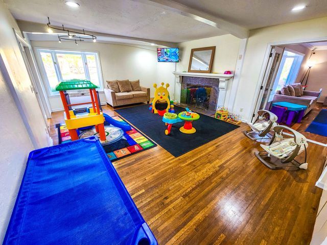 playroom with recessed lighting, wood finished floors, and a fireplace