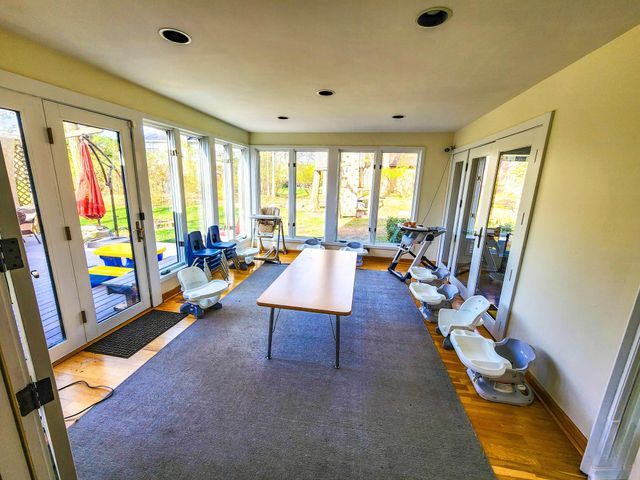 sunroom / solarium with a healthy amount of sunlight, french doors, and wood finished floors