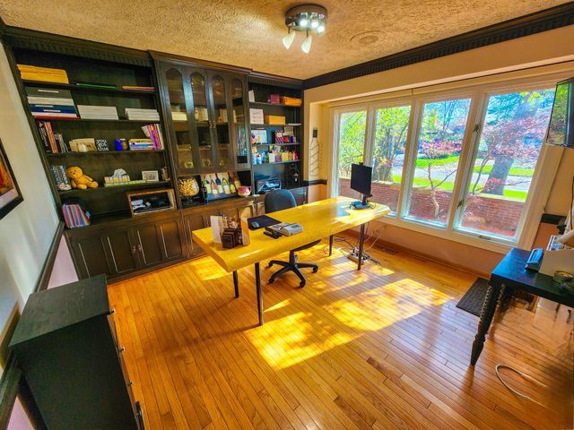office area with a textured ceiling and light wood-style flooring